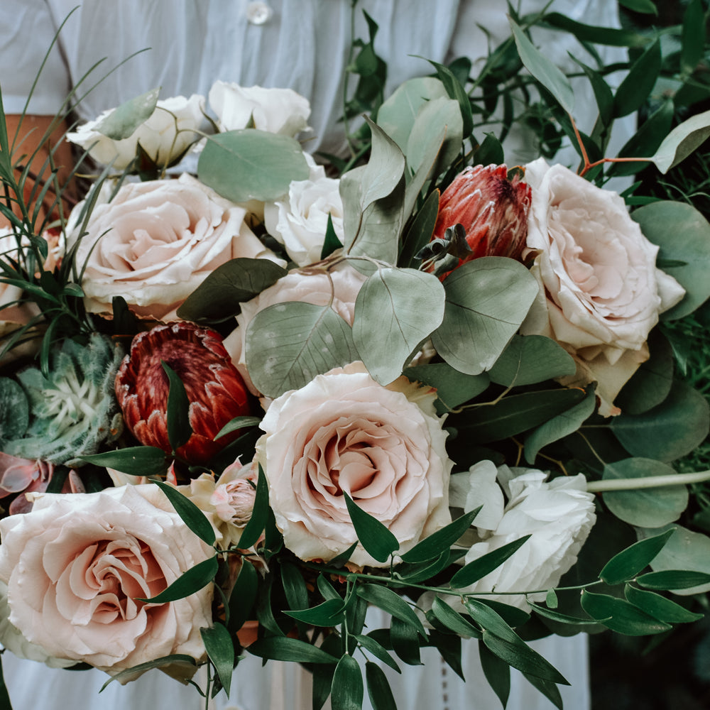 An arrangement of roses held by a person.